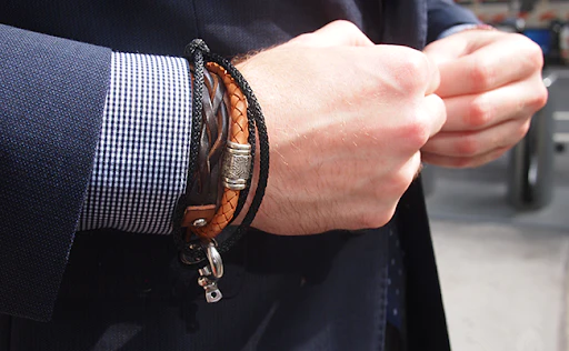 man with a suite and hand bracelets