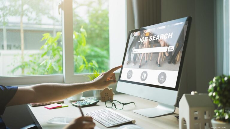 a women pointing finger towards laptop scree